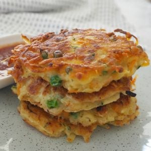 A stack of three golden fritters made with vegetables