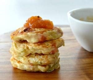 A stack of four pikelets made with ham, cheese and zucchini on a wooden bench