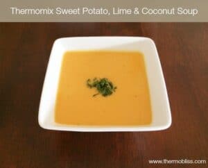 A square bowl of mustard coloured sweet potato soup, garnished with chopped coriander.