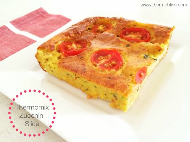 A square of zucchini slice with slices of tomato baked on the top.