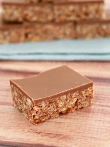 A piece of slice made with Mars Bars and Rice Bubbles and topped with a layer of milk chocolate.
