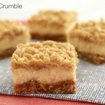 Squares of lemon crumble slice with a creamy lemon layer over the base and crunchy crumble on top.