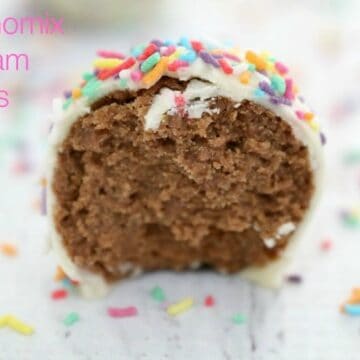 A Tim Tam ball with sprinkles on top, split in half to show chocolate texture inside.