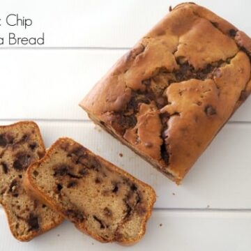 An overhead shot of a loaf made with banana and chocolate chips, with two slices cut to show chocolate chips throughout each slice.
