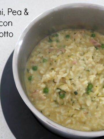Looking down into a Thermomix bowl filled with a zucchini, pea and bacon risotto.