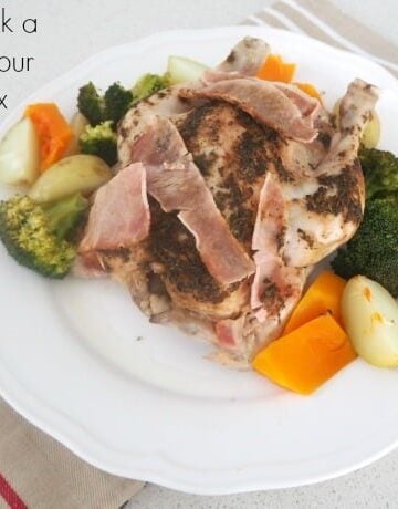 Potatoes, carrots and broccoli cooked and served on a plate with a whole cooked chicken.
