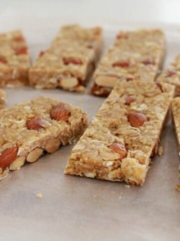 Bars of muesli slice, made with honey and nuts, on a bench.