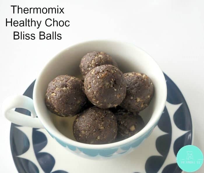 A pile of healthy bliss balls made with cacao, dates, nuts and chia seeds in a bowl.