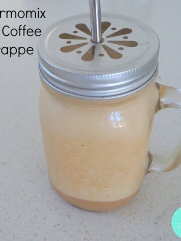 A mug with a handle and lid filled with an iced coffee frappe