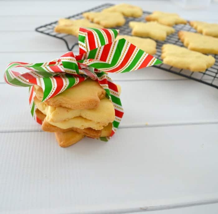 A stack of Christmas tree shaped shortbread tied with a red, white and green ribbon. 