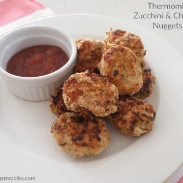 A small bowl of relish next to a pile of golden crunchy nuggets made with chicken and zucchini.