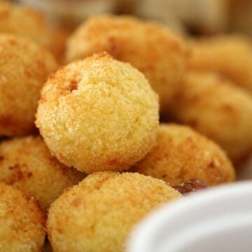 A close up of a pile of golden little arancini balls