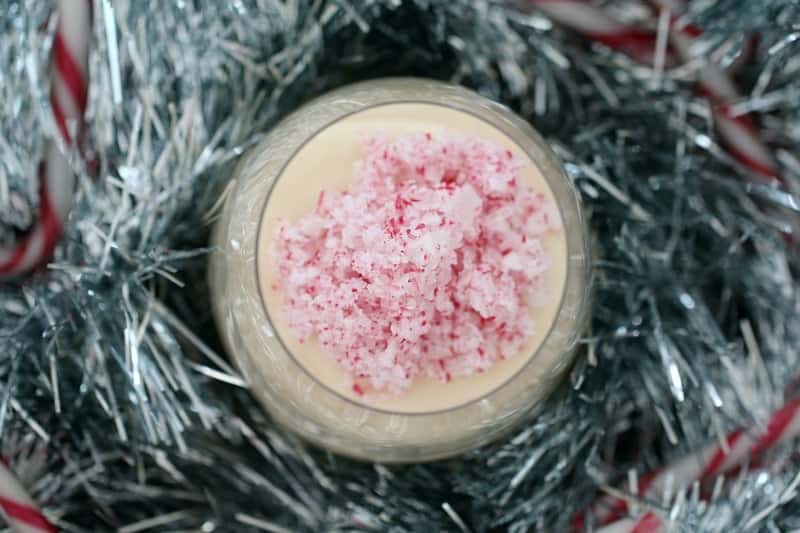 Crushed candy canes on top of a creamy cheesecake filling in a glass jar.
