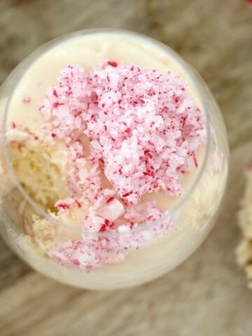 A glass jar of cheesecake with crushed candy canes.
