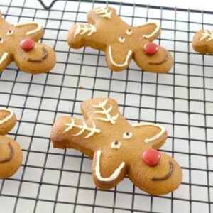 Gingerbread men decorated as reindeer on a black wire tray.