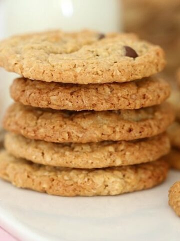A close up of a stack of oat cookies made with chocolate chips