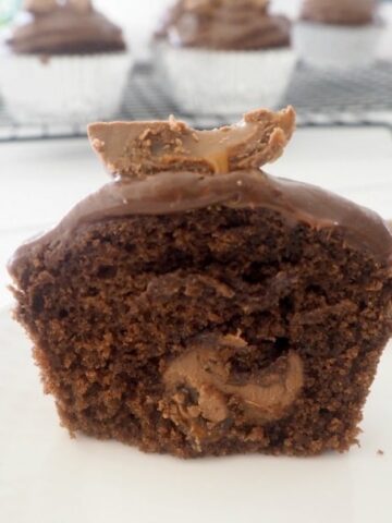 A close up of a chocolate cupcake split in half to show melted Creme Easter eggs inside.