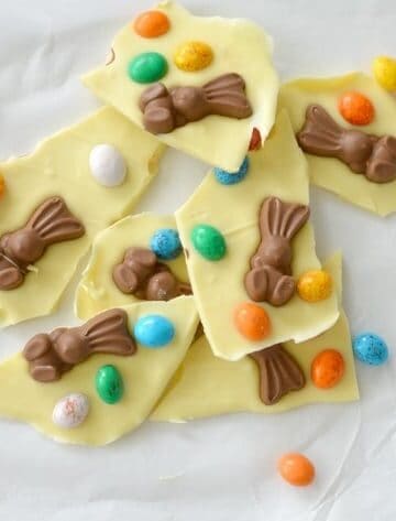 Pieces of white chocolate Easter bark topped with chocolate bunnies and coloured mini Easter eggs.
