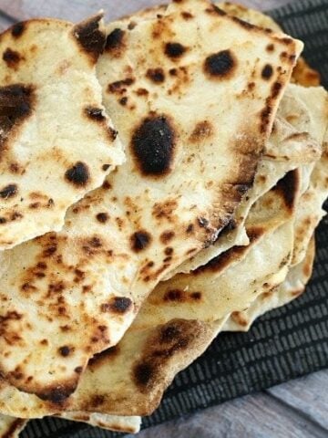 A stack of baked roti bread torn into pieces.