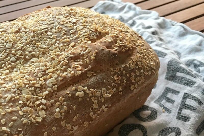 A loaf of crusty bread with oats and grains on top.