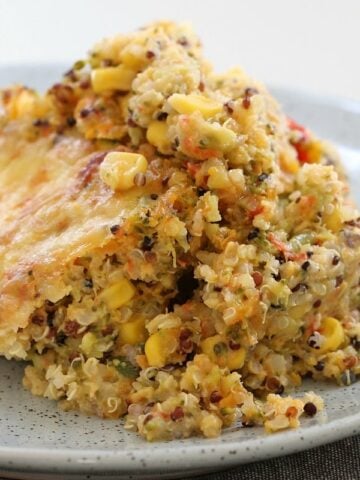 A serve of quinoa bake made with vegetables and cheese, on a plate.