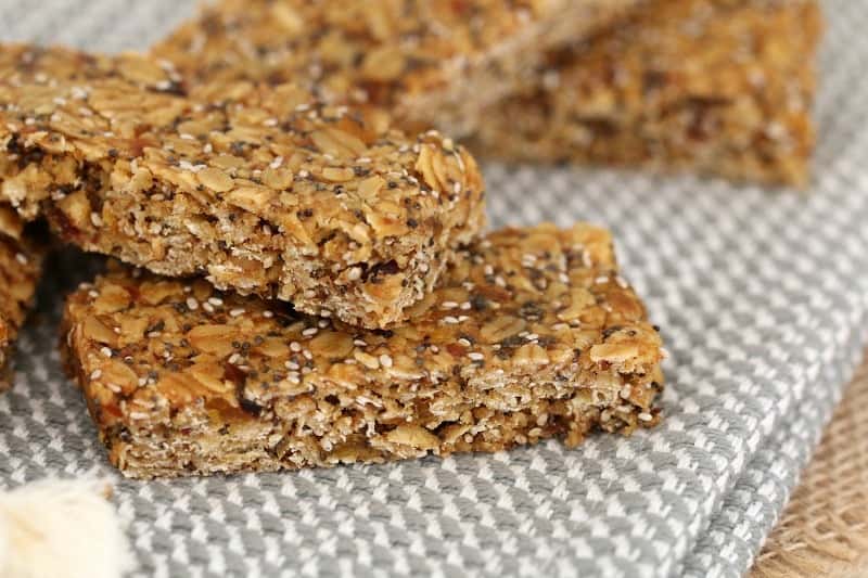 A close up of homemade muesli bars filled with oats, seeds, dates and dried apricots.