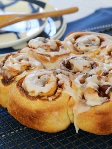 A round of golden scrolls made with apple and cinnamon rolled inside, and drizzled with white icing.