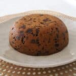 A white plate with a Christmas pudding on it.