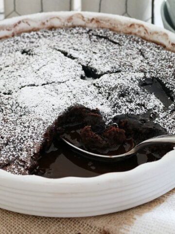 Chocolate sauce showing under a chocolate pudding baked in a round baking dish.