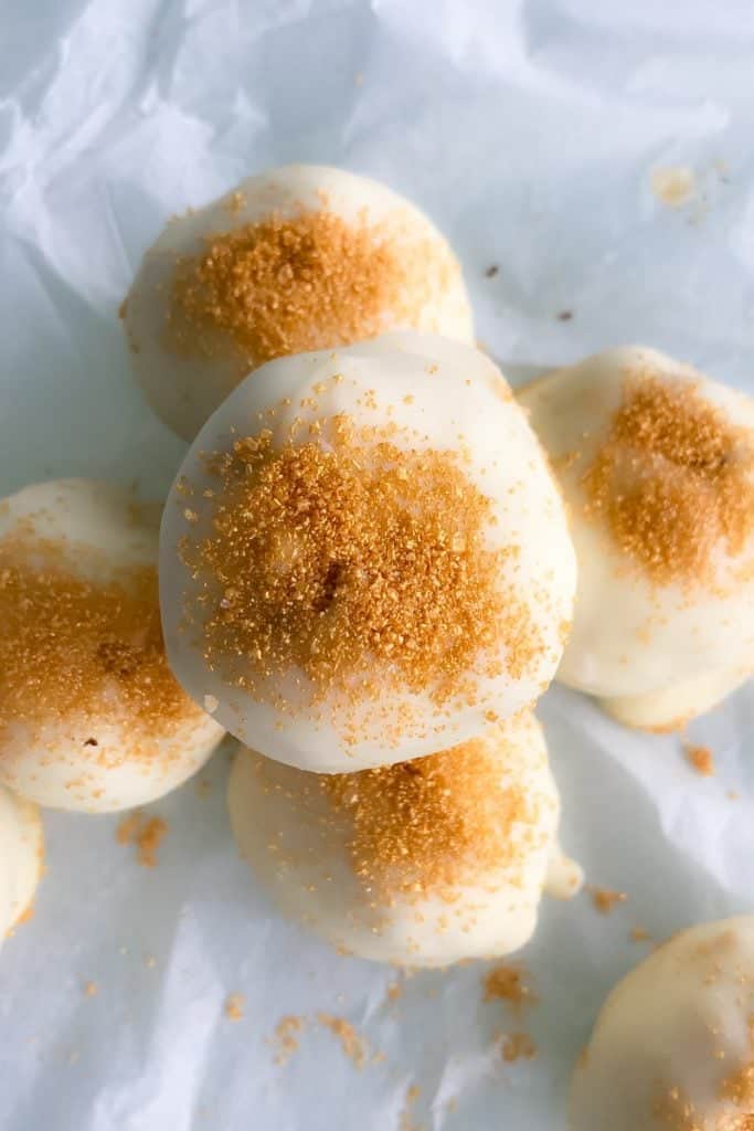 A pile of white chocolate coated balls, sprinkled with a fine caramel coloured topping.