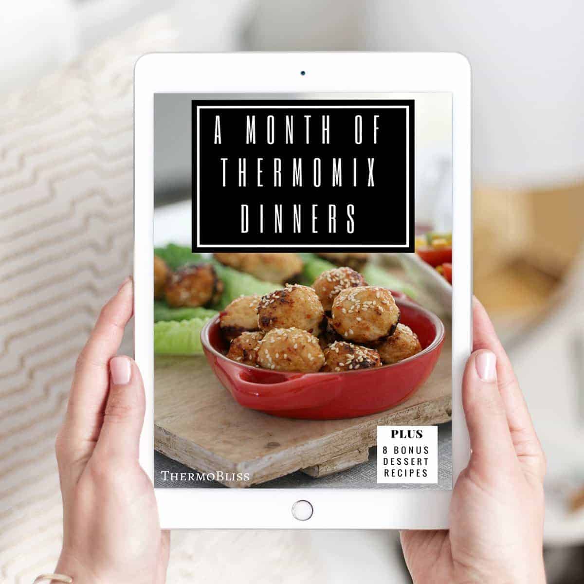 Two hands holding a recipe book - A Month of Thermomix Dinners