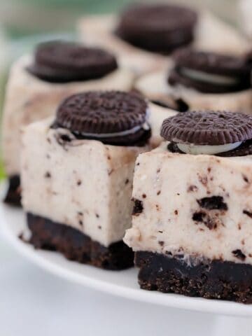 An Oreo biscuit on the top of each square of a chocolate cheesecake slice made with crumbled Oreo biscuits