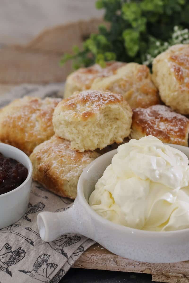 Scones with a bowl of whipped cream next to it. 