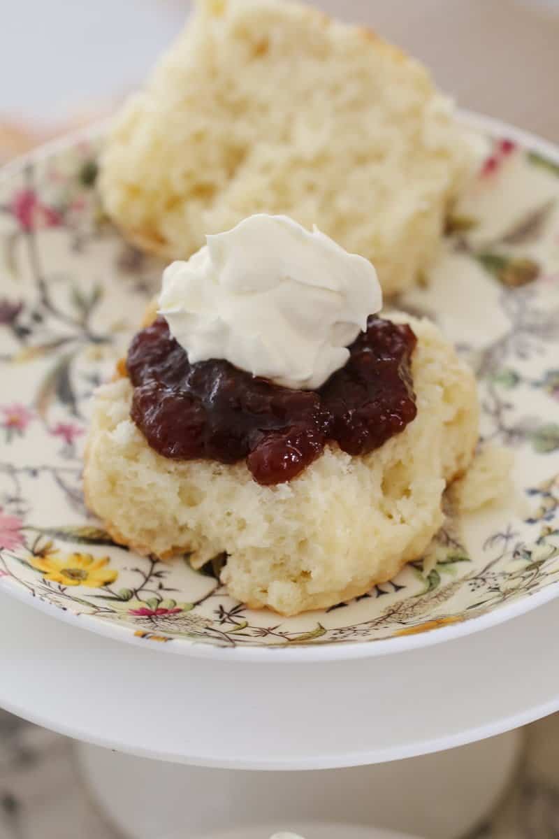 Jam and cream on top of half a scone.