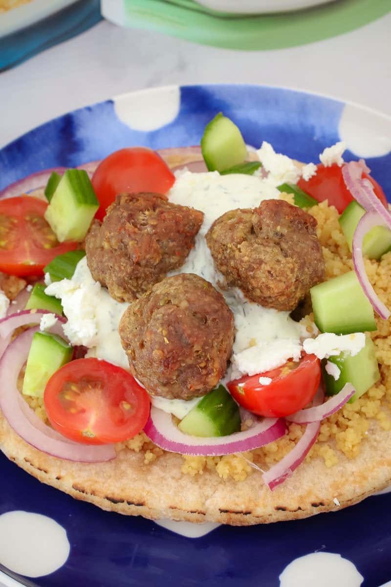 Baked meatballs with salad ingredients on a pita bread