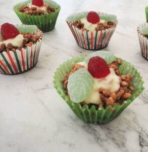 Chocolate crackles made with Rice Bubbles decorated with spearmint leaves and raspberry lollies to resemble holly