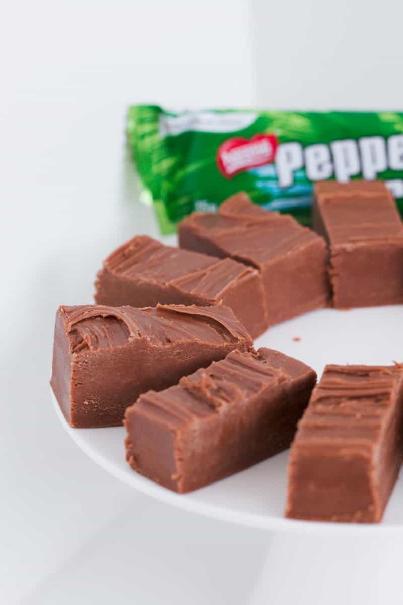 A peppermint crisp chocolate bar behind pieces of chocolate mint fudge.