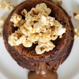 Popcorn on top of a chocolate dessert with chocolate sauce oozing out the side