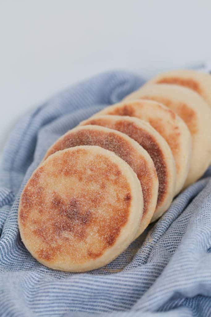 Several english muffins dusted with semolina. 