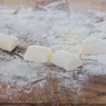 Homemade gnocchi on a floured wooden board.