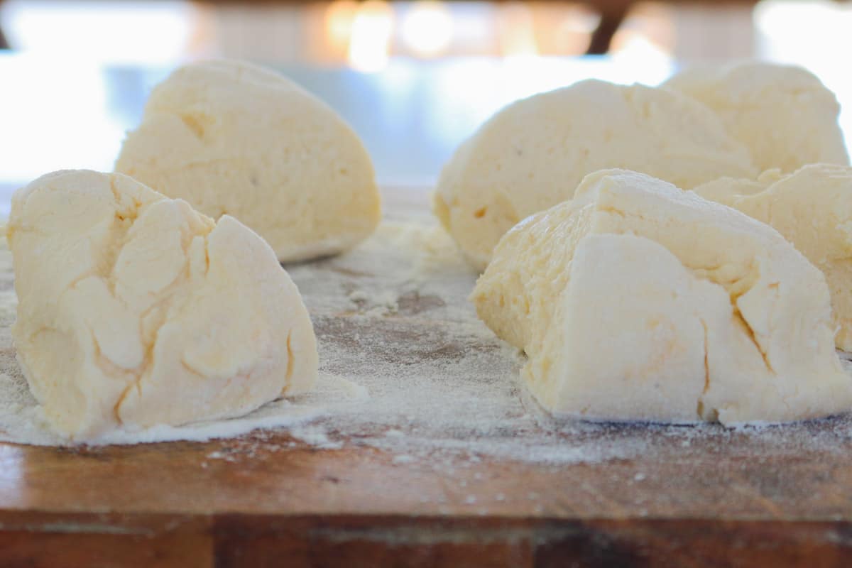 Ricotta dough divided into sections on a board.