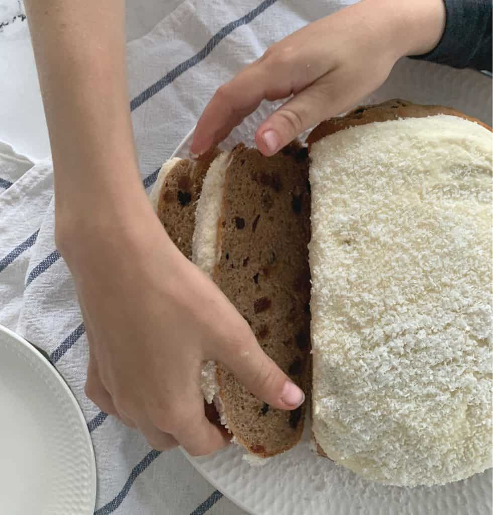 Top view of Boston Bun with kids reaching for a slice