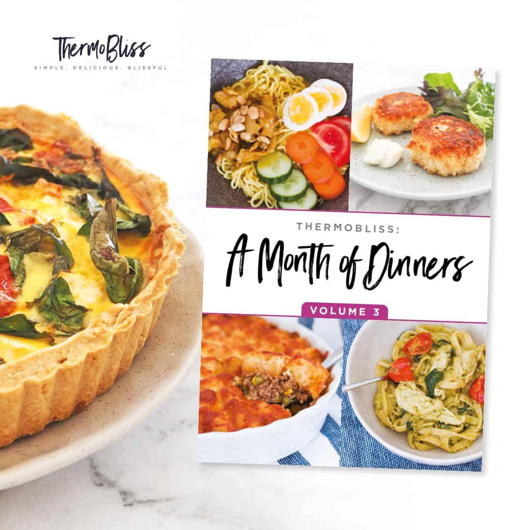 A quiche next to a 'Month of Dinners Volume 3' recipe book.