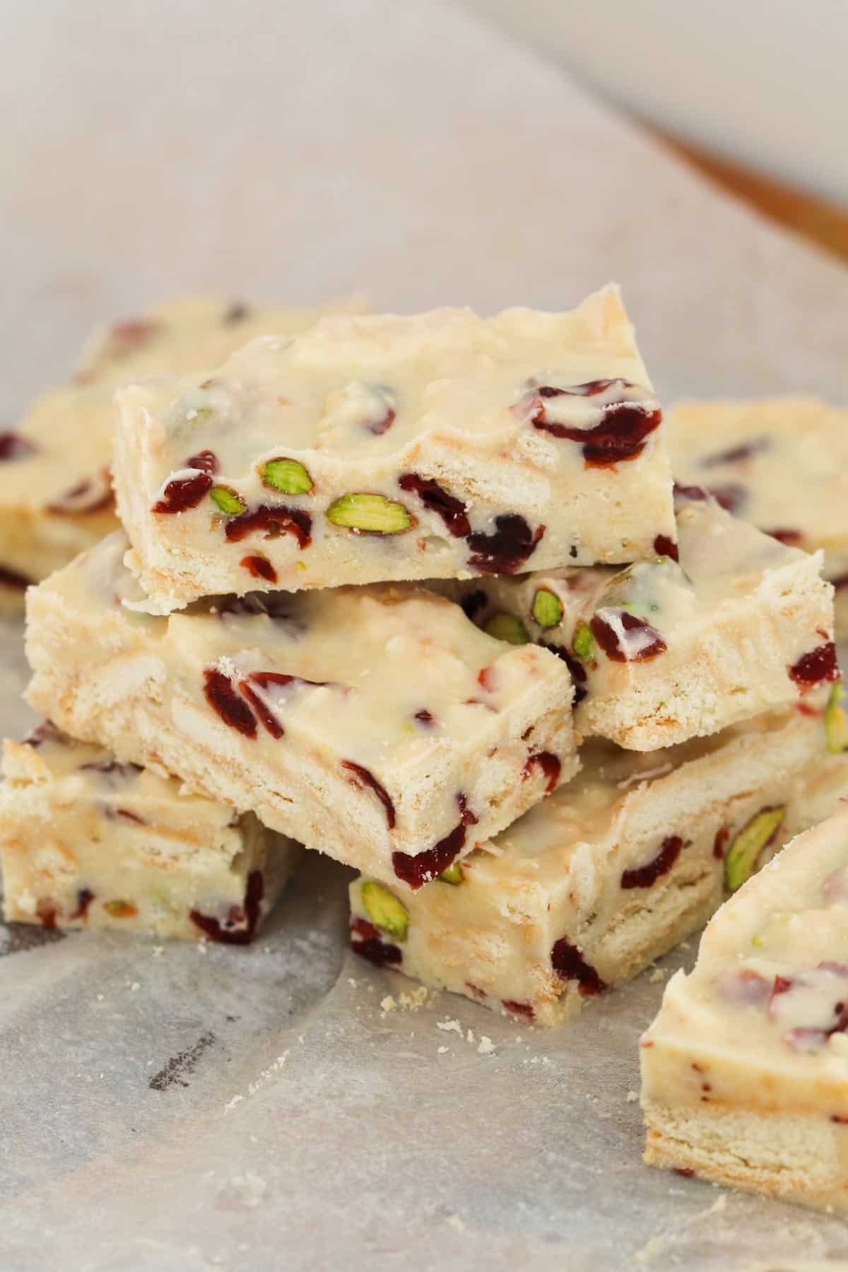 A stack of pieces of hedgehog slice with pistachios and cranberries.
