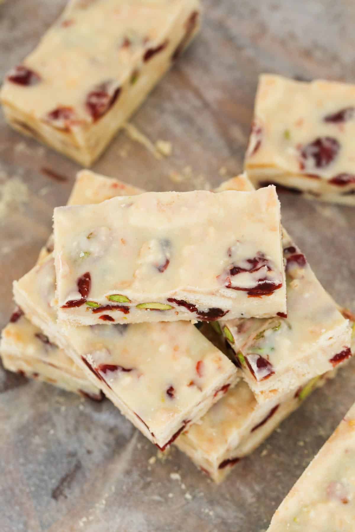 A pile of rectangles of pistachio and cranberry slice.