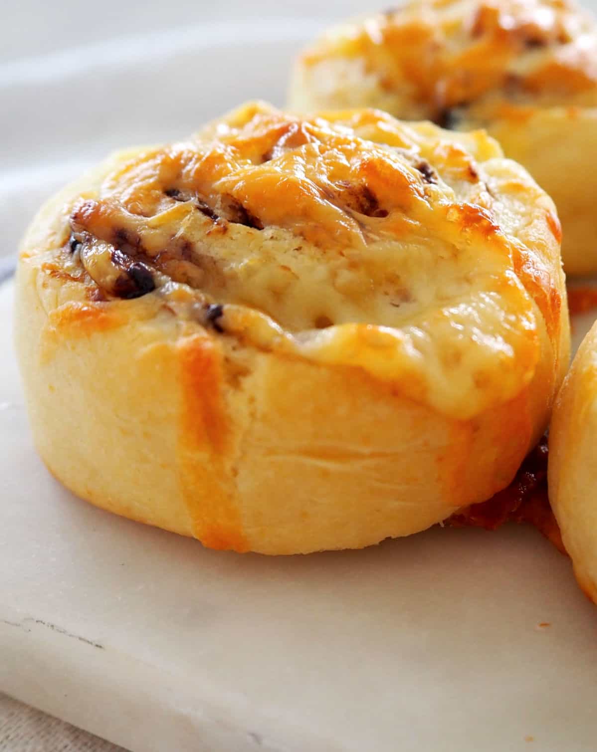 side view of cheese and vegemite scrolls on platter