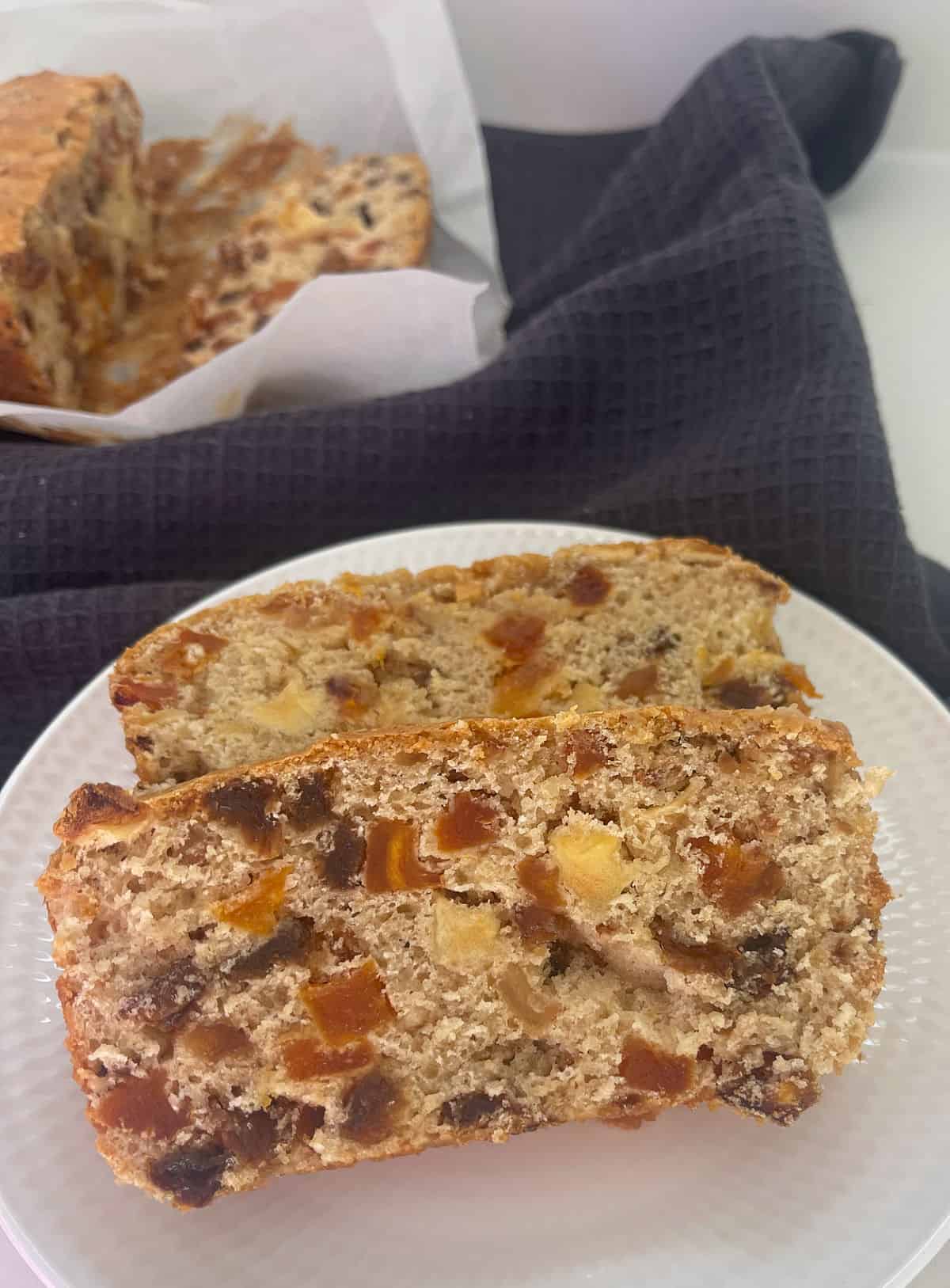 Two slices of Fruit Loaf made in a thermomix on a white plate.