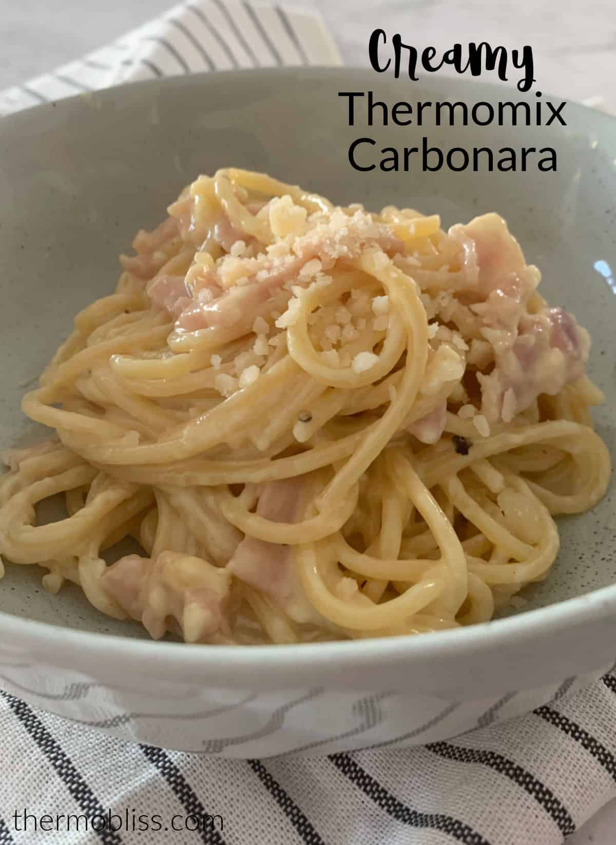 side view of creamy carbonara in a  green bowl