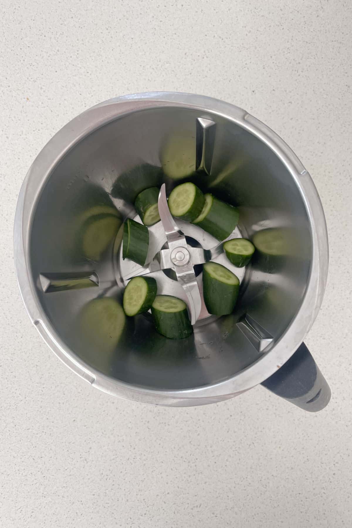 Chopped cucumber pieces in a thermomix bowl.
