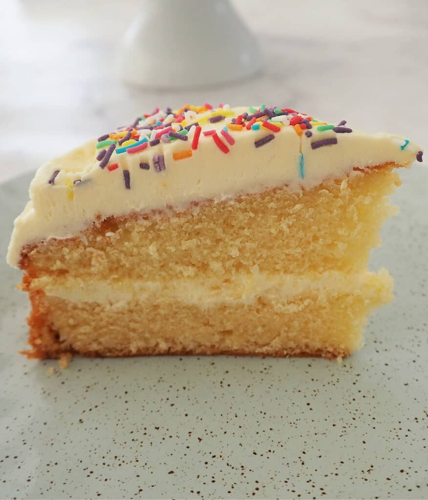 Slice of butter cake on green speckled plate